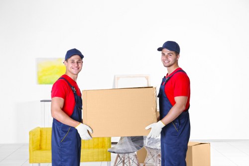 Professional movers handling household items and packing materials